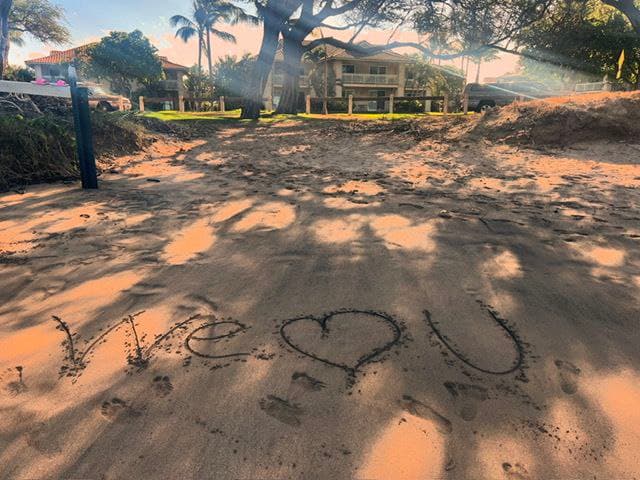 We love U written in the sand on a Maui beach at sunset